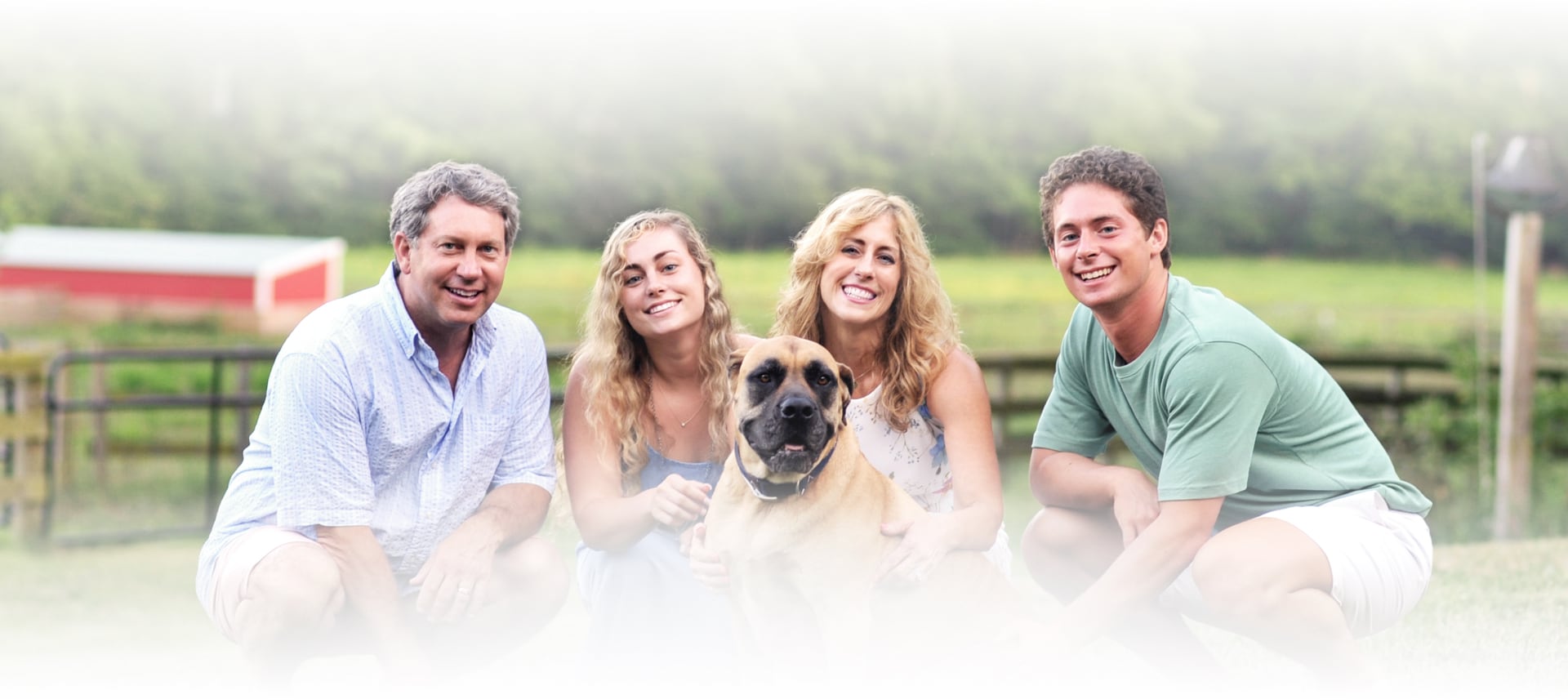 family smiling with a dog
